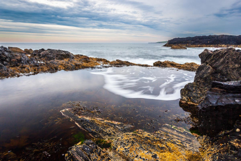 Wellen und Gezeitentümpel in Portsoy, Schottland