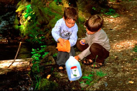 Esra und Noah spielen am Bach, Big Sur, Californien