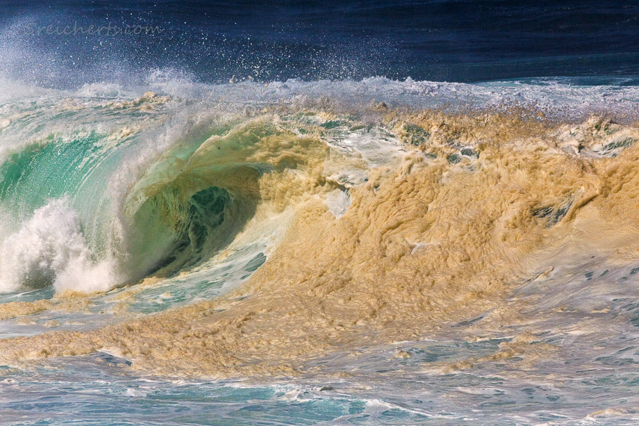 Wellen am Cabo Silleiro wirbeln Sand auf