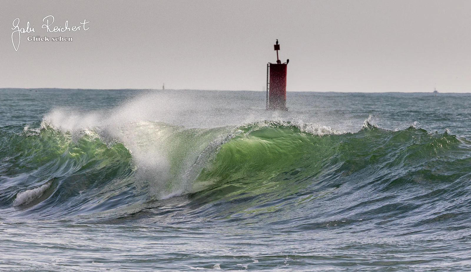 Welle rollt auf die Hafenmauer zu